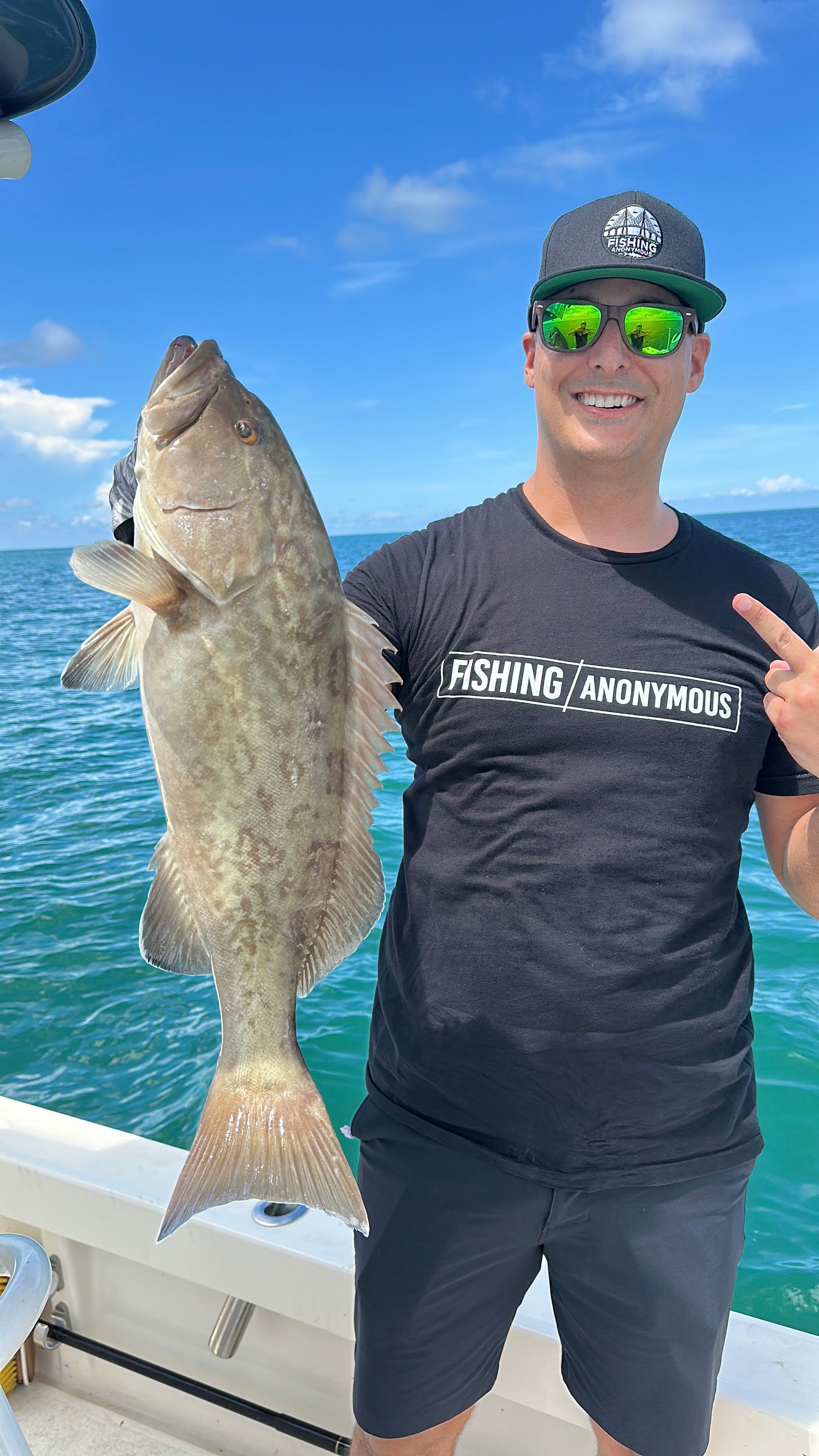 Fishing Anonymous founder wearing polarized sunglasses and holding a grouper on the Gulf