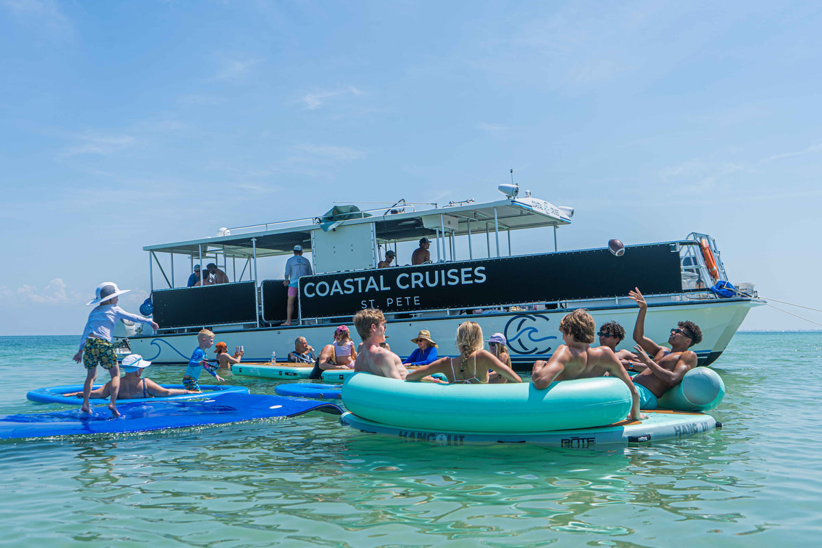 Family and friends relaxing beside a Coastal Cruises catamaran in Tampa Bay